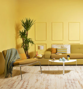 a living room with mustard colored walls, mustard colored couch and chair