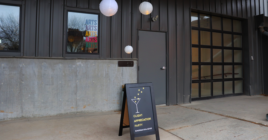 The entrance to Amplify Arts, with a sandwich board in front that says "client appreciation party." 